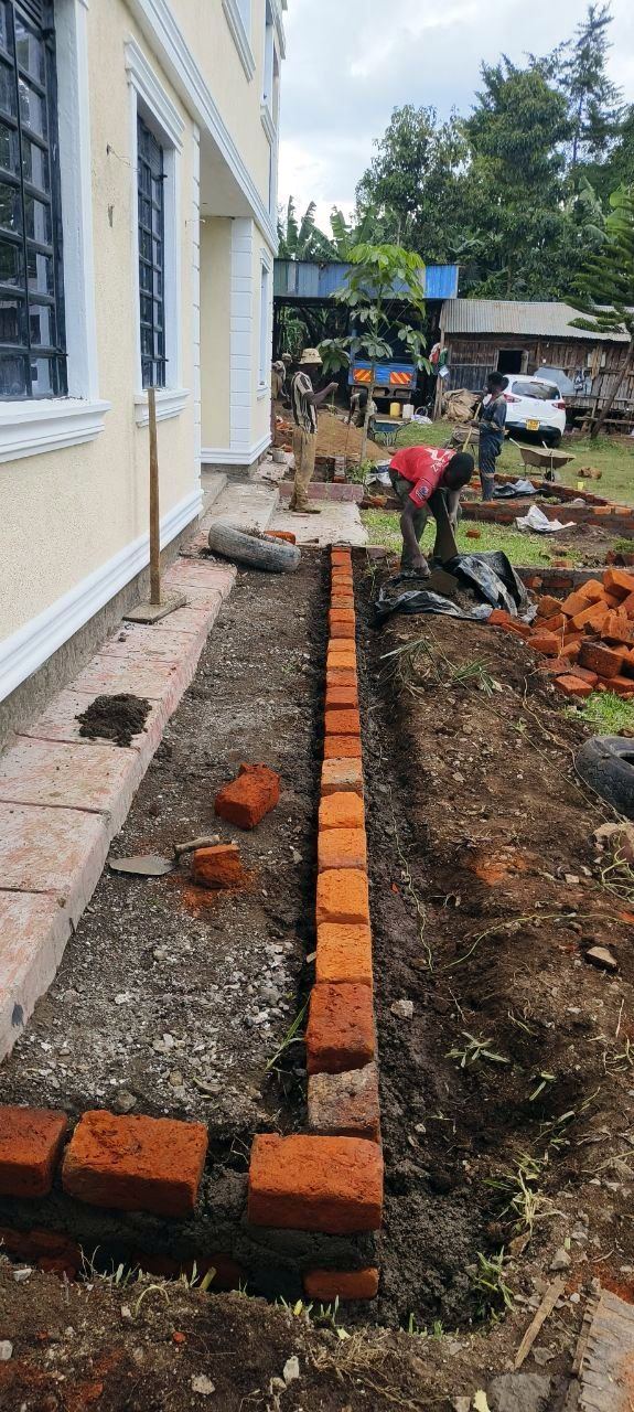 Brick edging being laid along a new garden bed