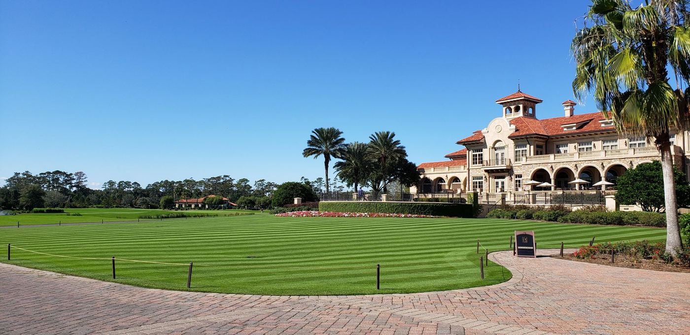 Estate clubhouse with a striped lawn and paved path