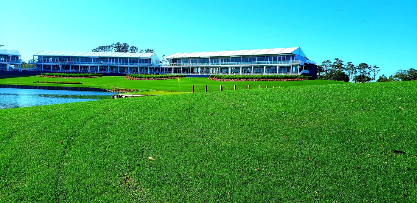 Long building beside a lake and mown lawn